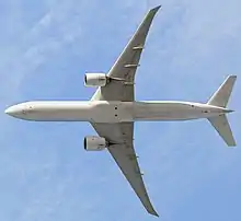 飛機飛行時的底面視圖。這架噴氣式飛機的兩個機翼各有一台發動機。圓形的鼻子通向筆直的身體部分,在帶有兩個後鰭的尾部逐漸變細。